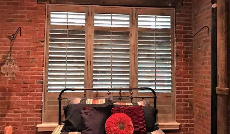 Reclaimed wood shutters next to brick wall.